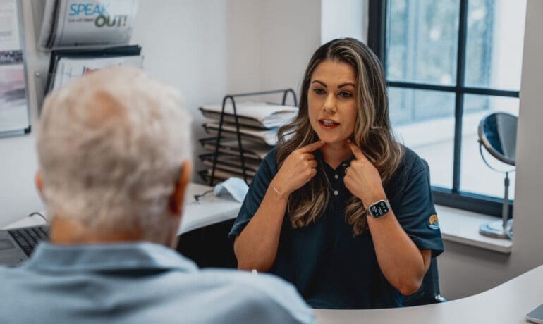 Therapist providing one-on-one speech therapy to support communication and daily function